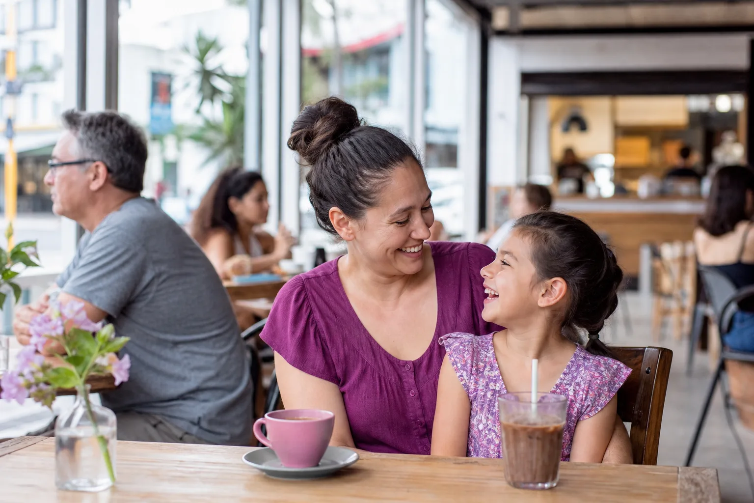 Single mother enjoying coffee at an outdoor Sydney café